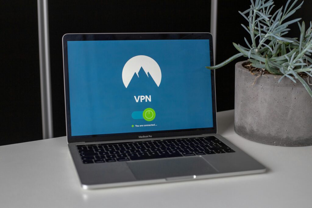 pexels-photo-2064586-2064586 Laptop with VPN screen and a succulent plant on a desk, emphasizing online privacy and security.